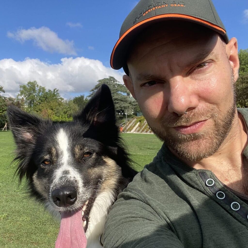 Homme et chien souriants dans un parc verdoyant.